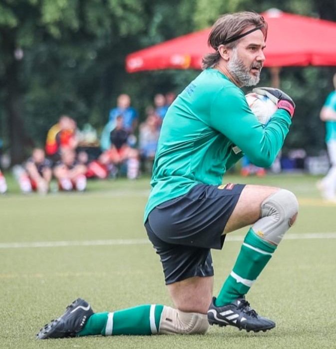 Andreas Barås som målvakt på knä med bollen på en fotbollsplan.